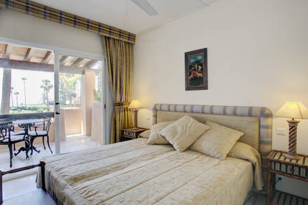 Image shows the second bedroom with large doube bed and view onto terrace