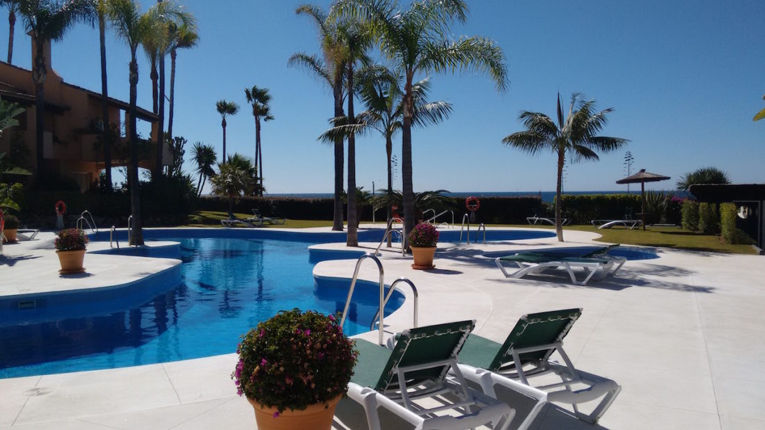 Holiday Rentals Estepona Image shows the shared pool facility along with some sund beds.