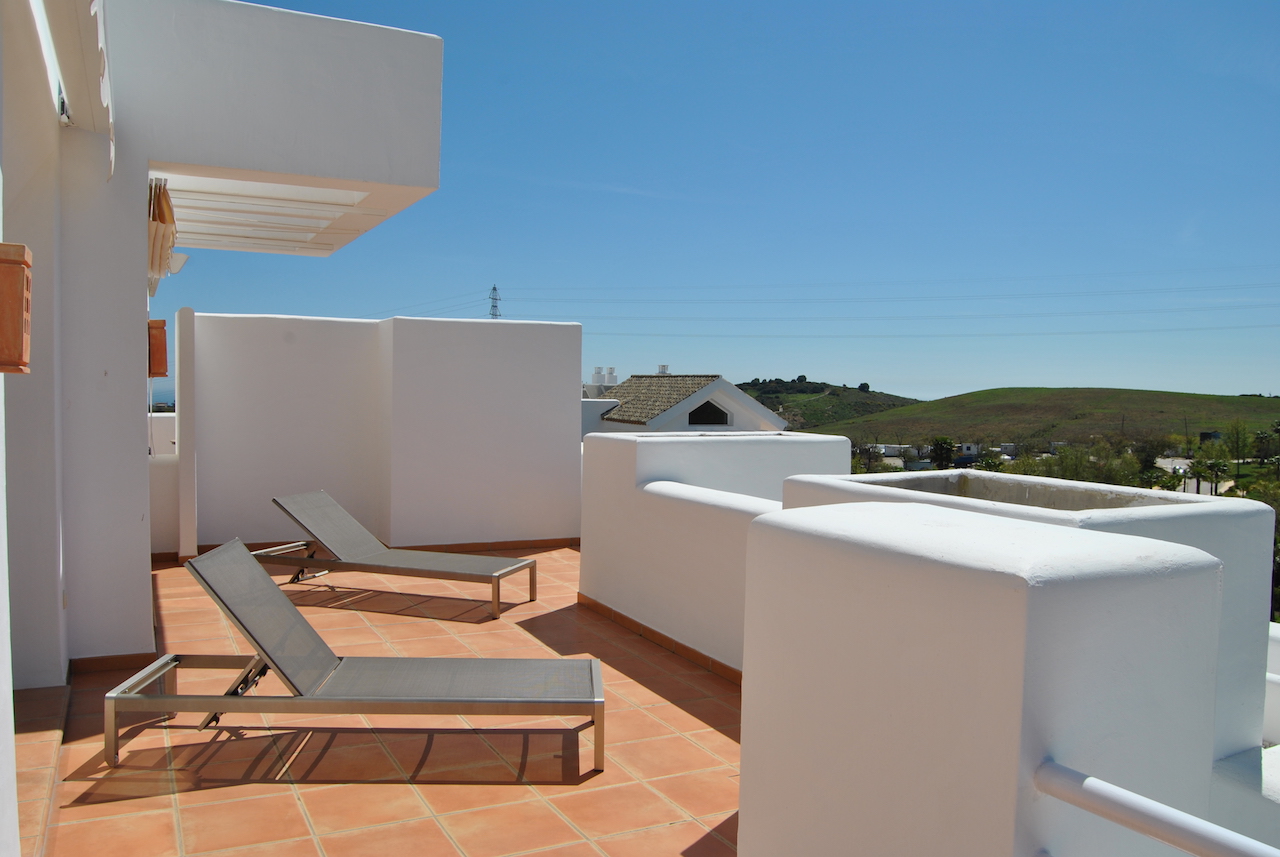 Image shows large terrace with sunloungers