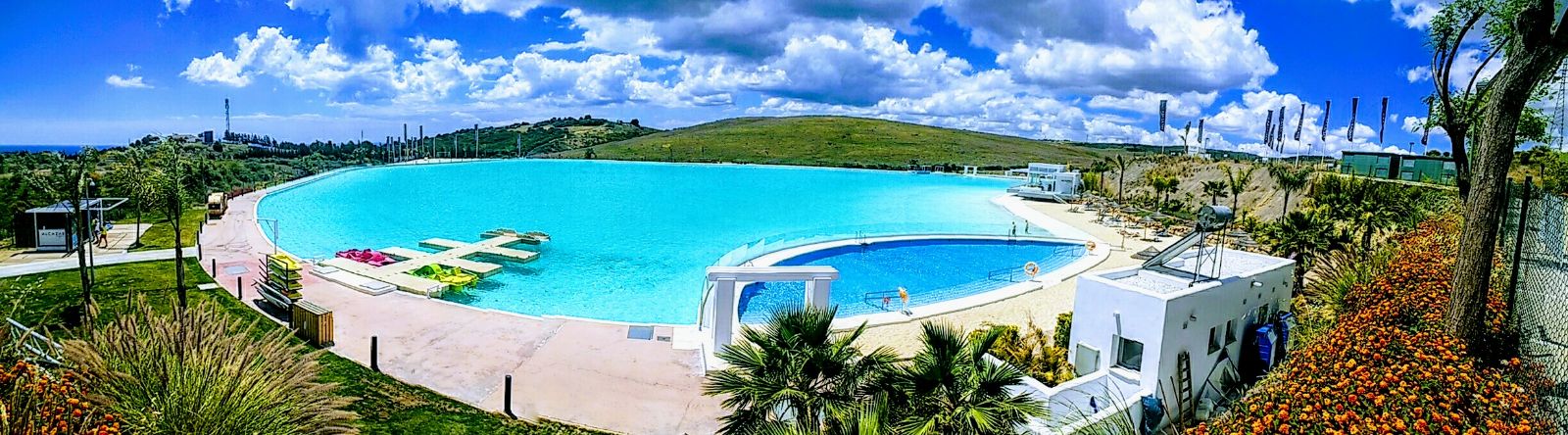 Image shows panoramic view of the crystal lagoon and blue skies