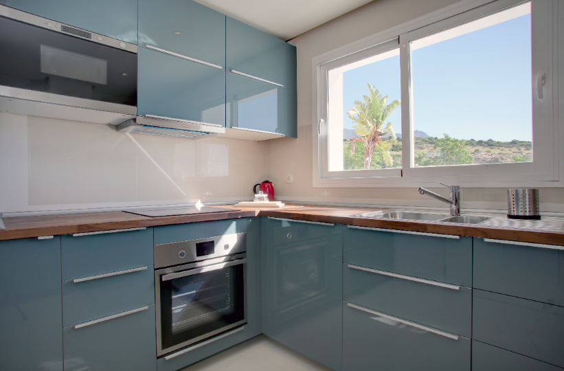Image shows large modern kitchen with views to mountains