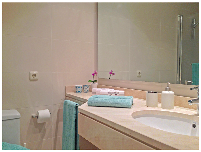 Image shows marble bathroom with bath tub