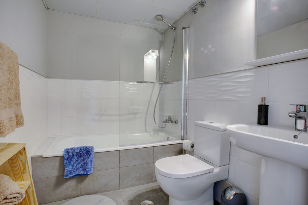 Image shows a bahroom with a bathtub and shower