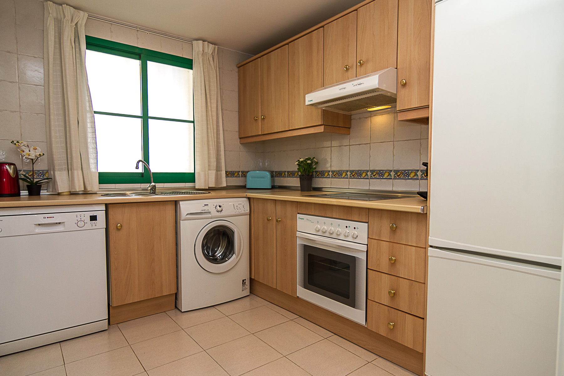 Image shows kitchen with washing machine and dishwaher