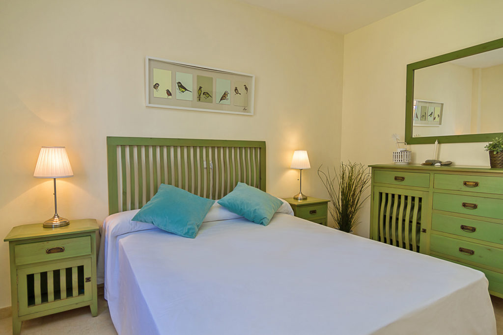 Image shows double bed in green tones