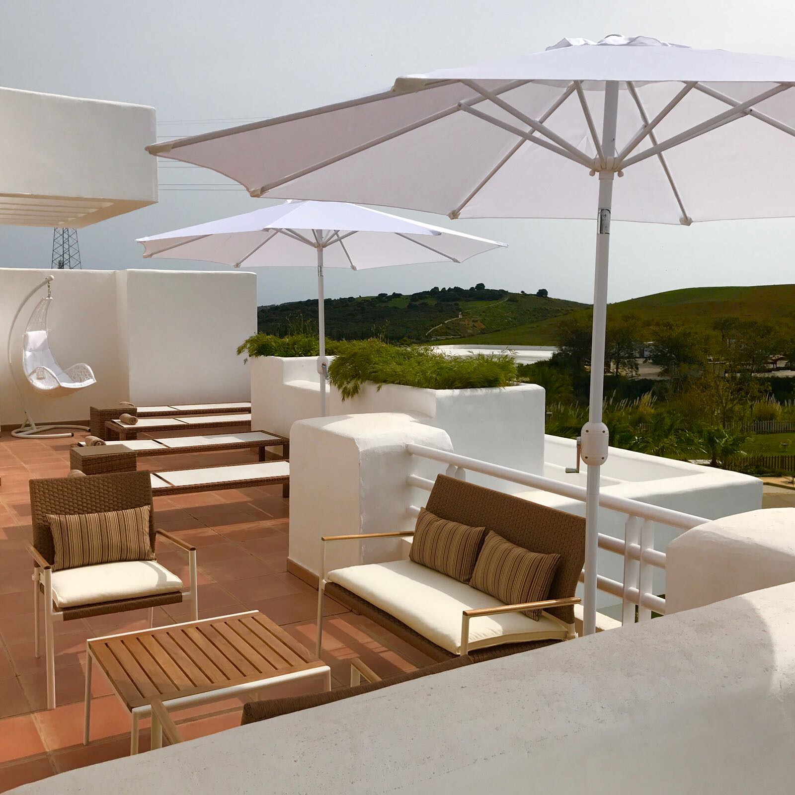Image shows the terrace including table, chairs and sunbeds of this stylish penthouse in Alcazaba Lagoon