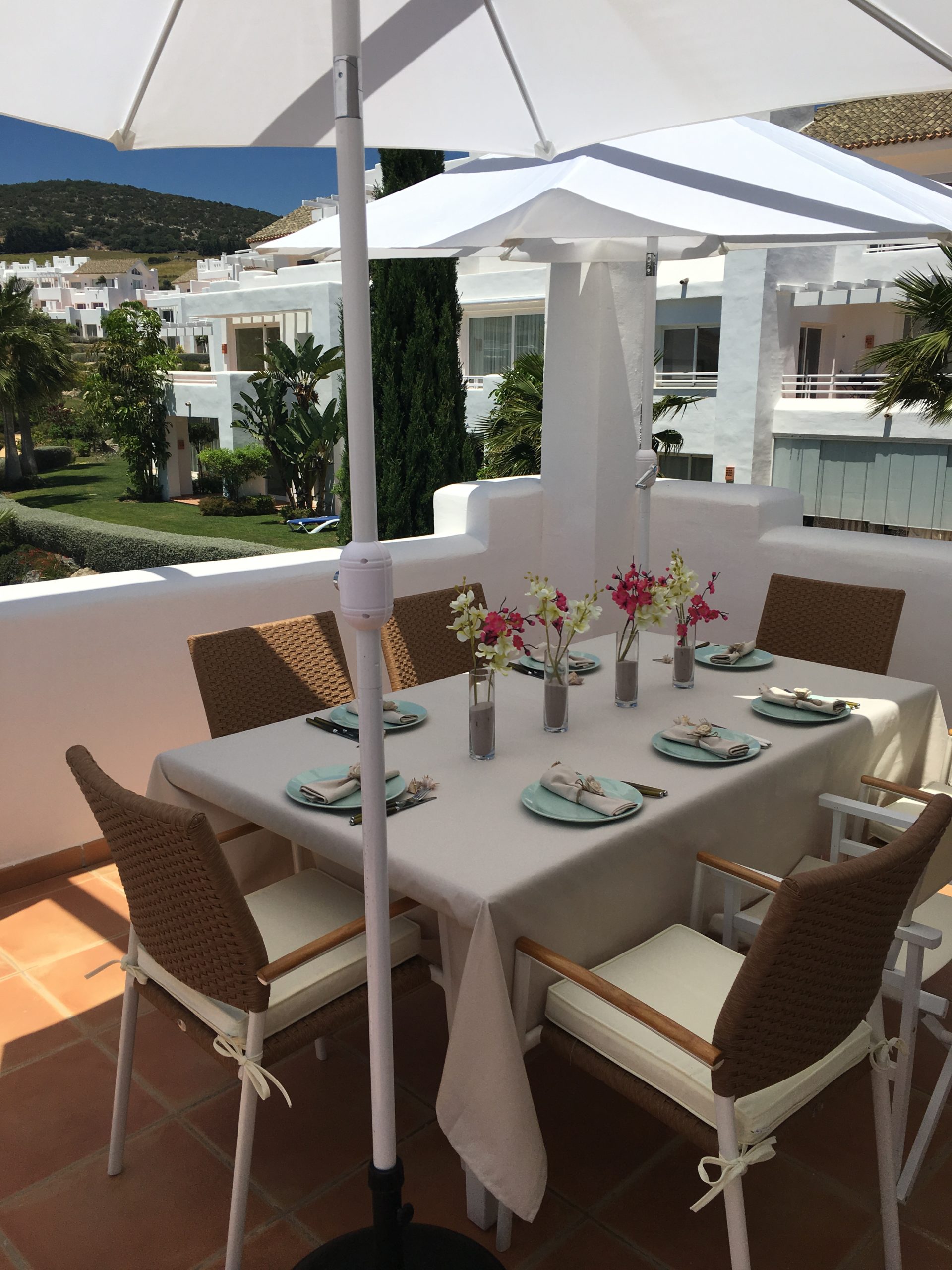 Image shows the dining table on the terrace of this stylish penthouse in Alcazaba Lagoon set for a meal